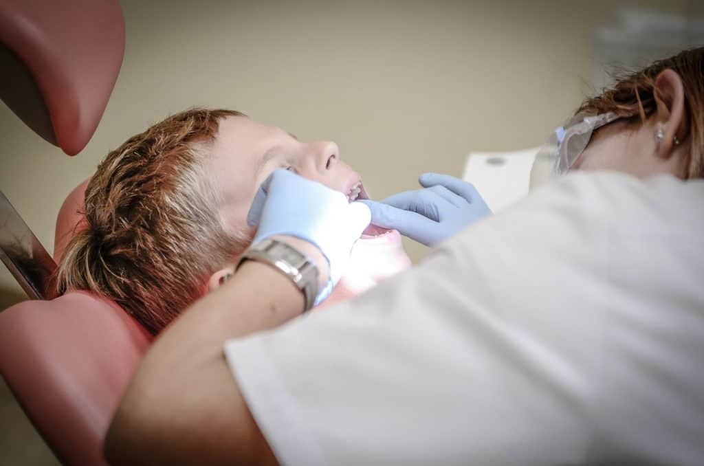 Zahnarzt untersucht die Zähne eines Jungens