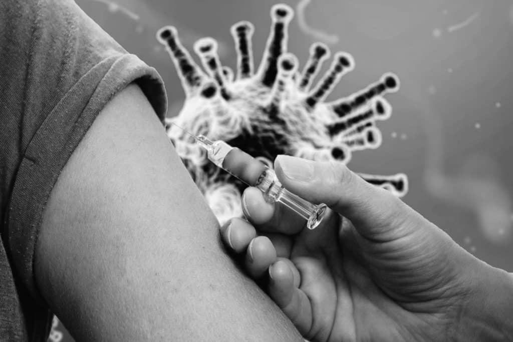 Arm, an den eine Spritze mit Impfstoff gehalten wird als Zeichen für die Impfung gegen HPV Viren